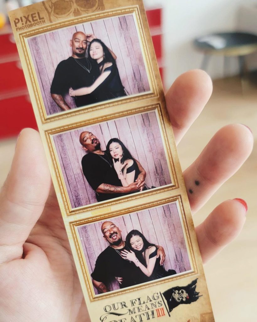 Ruibo Qian holds a set of photobooth photos with herself and an unknown crew member.