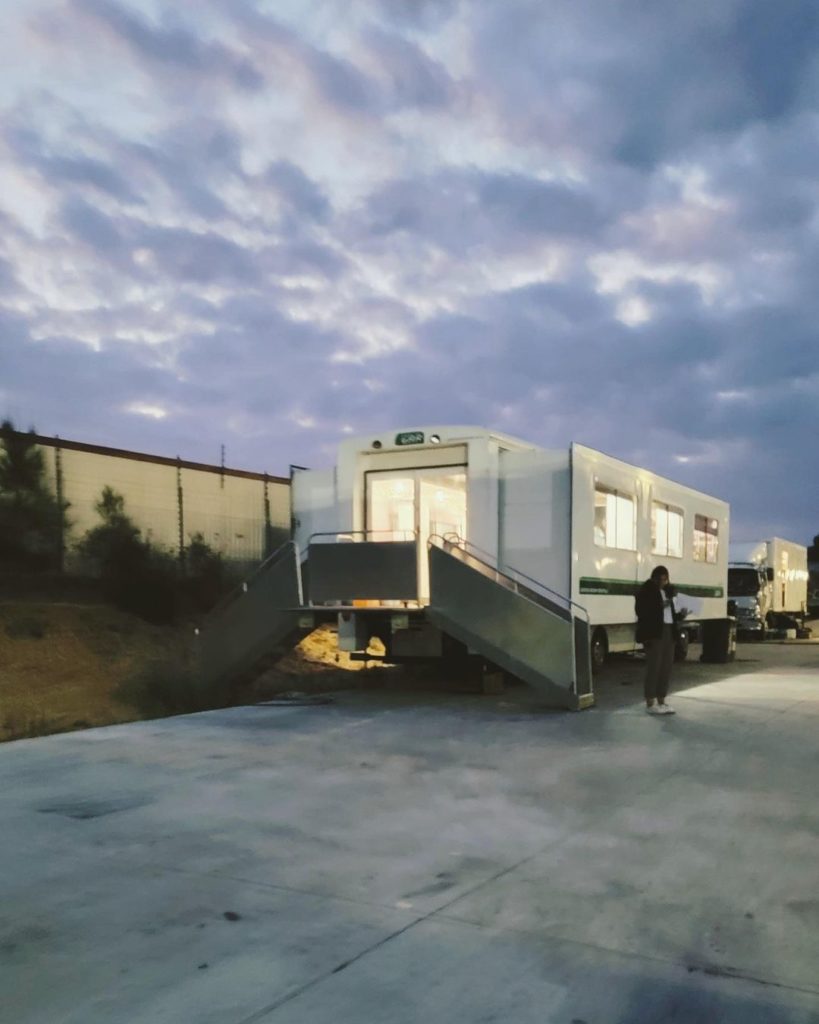 A picture of a trailer, likely Ruibo Qian's at Kumeu Film Studios. Someone stands outside of it.