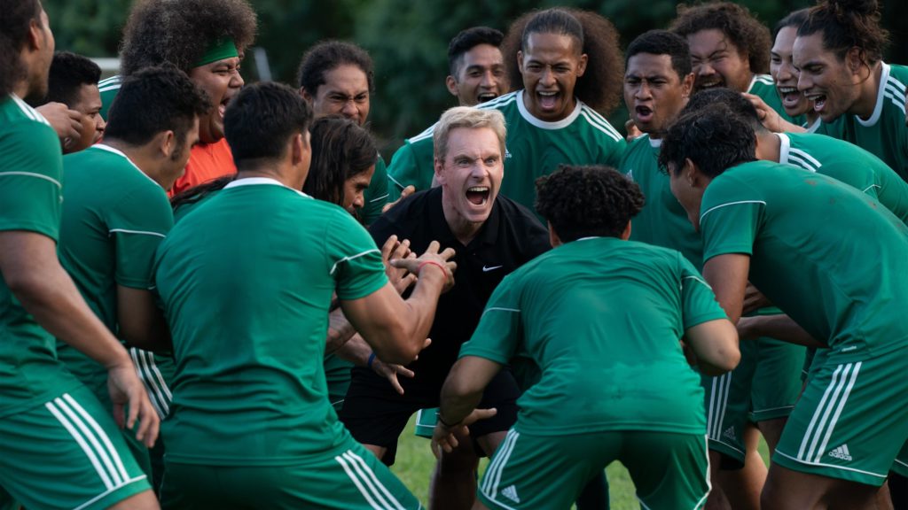 Screenshot from "Next Goal Wins." Michael Fassbender screams with his team from the center of his team’s scrum.